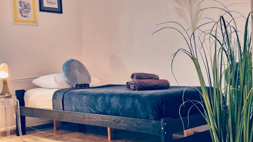 Una cama con dos bolsas junto a una planta. en Apartament na poddaszu M.CH. - Ustka, en Ustka