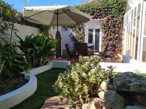a patio with an umbrella and some plants at Villa les Pins in Jávea