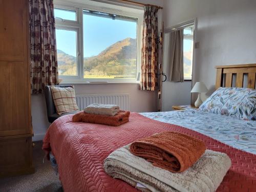 ein Schlafzimmer mit einem Bett und einem großen Fenster in der Unterkunft Holly Cottage Grasmere in Grasmere