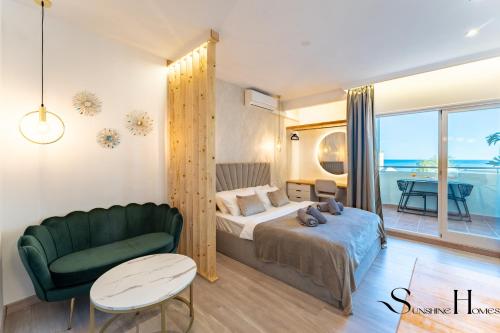 sypialnia z łóżkiem i zieloną kanapą w obiekcie Seaview beachfront studio with aqua park & balcony w mieście Benalmádena