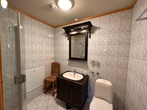 Un baño con lavabo, inodoro y espejo. en Beitotind 1504, en Beitostølen