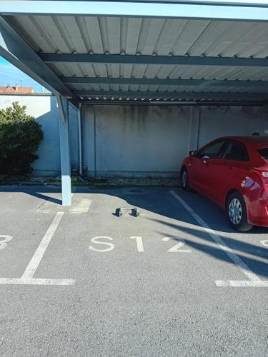a red car parked under a parking lot at Apartman Tina ***** s jacuzzijem u blizini Parka prirode Papuk in Szlatina