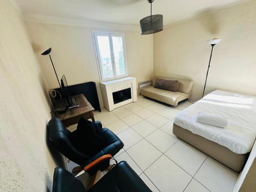 une chambre avec un lit, un canapé et une chaise dans l'établissement Appartement confortable, à Nice