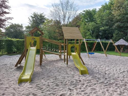 a playground with a slide in the sand at Camping de Beukenhof in Tiendeveen
