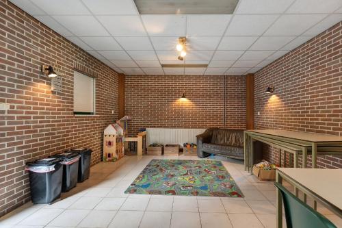 a living room with a brick wall and a rug at Camping de Beukenhof in Tiendeveen