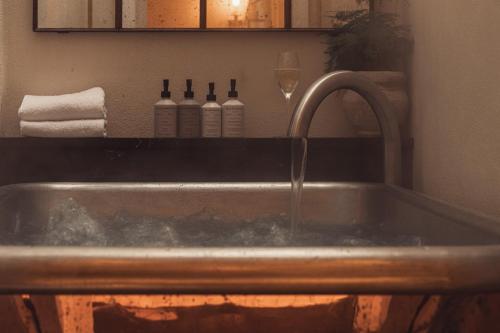 a kitchen sink with a faucet and two bottles of wine at No.124 by GuestHouse, Brighton in Brighton & Hove