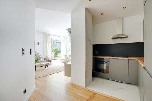 une cuisine avec des placards blancs et un mur noir dans l'établissement Suite Double Ranelagh, à Paris