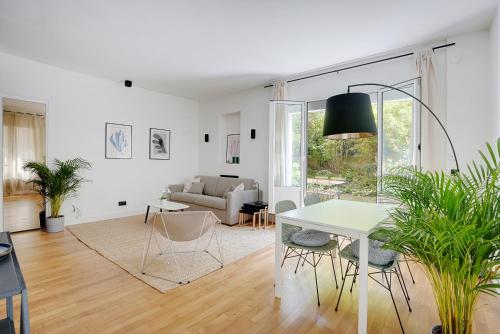 un salon avec une table, des chaises et un canapé dans l'établissement Suite Double Ranelagh, à Paris