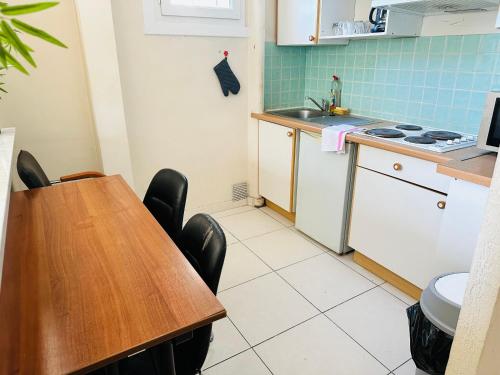 une cuisine avec une table, un évier et une cuisinière dans l'établissement Appartement confortable, à Nice