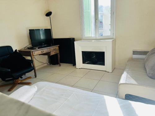 - une chambre avec un lit, une télévision et une cheminée dans l'établissement Appartement confortable, à Nice
