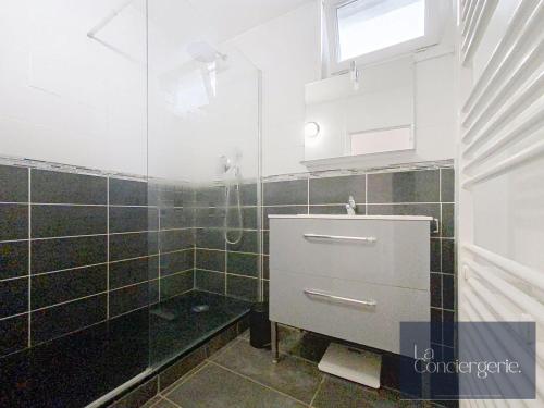 La salle de bains est pourvue d'un lavabo et d'un mur carrelé. dans l'établissement Appart avec vue-Les Rocs-Poitiers-LaConciergerie, à Poitiers