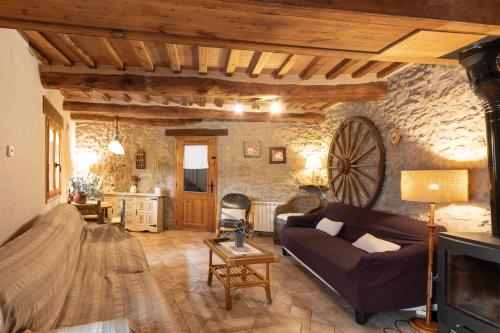 a living room with a couch and a tv at Cal Torrentí in Caserras