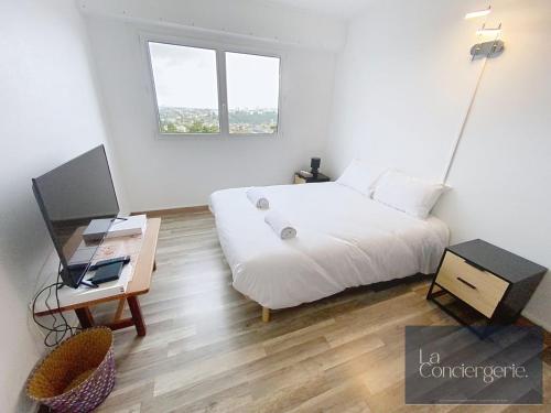 une chambre avec un lit et un bureau avec une télévision dans l'établissement Appart avec vue-Les Rocs-Poitiers-LaConciergerie, à Poitiers