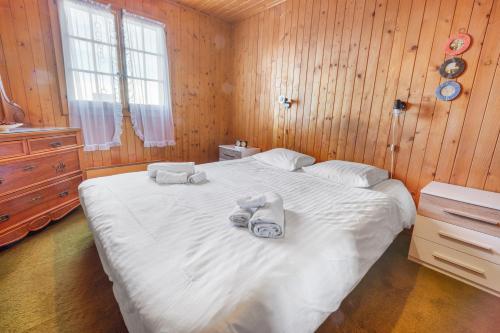 a bedroom with a large white bed with towels on it at Chalet familial avec vue sur les Alpes et le lac, sur les hauts de Montreux à Caux in Caux sur Montreux