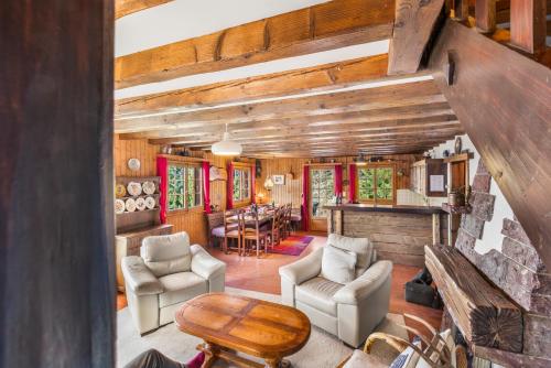 a living room with a stone fireplace in a house at Chalet familial avec vue sur les Alpes et le lac, sur les hauts de Montreux à Caux in Caux sur Montreux