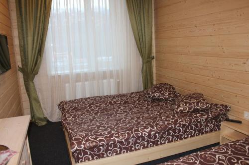 a bedroom with a bed in a room with a window at Туристичний комплекс ВОРОХТА 365 Turistichesky Kompleks Vorokhta 365 in Vorokhta