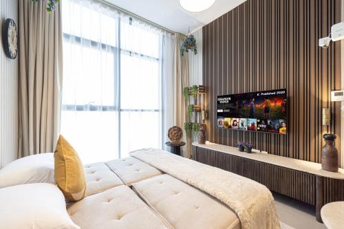 a bedroom with a bed and a flat screen tv at 1BR Wanderlust Apartment by Blue Cloud Holidays in Sharjah Intl