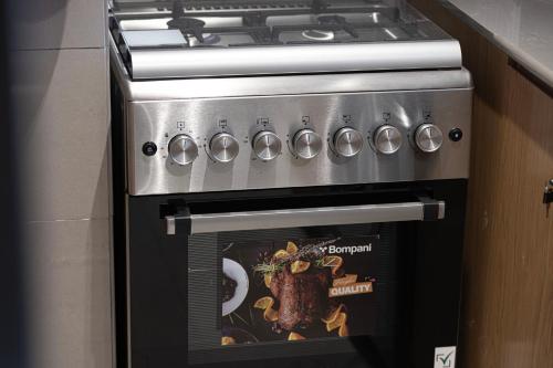 a stove top oven with a picture of a steak at 1BR Wanderlust Apartment by Blue Cloud Holidays in Sharjah Intl