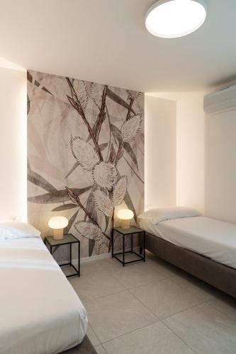 a bedroom with two beds and a wall mural at Appartamenti "Primula - Fiordaliso" - Cascina Da Rosa in Capiago Intimiano