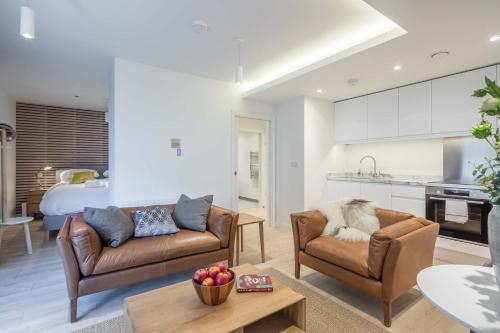 a living room with two couches and a kitchen at Stunning Central Apt With Parking in Cambridge