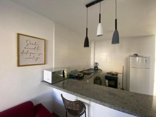 a kitchen with a counter top and a refrigerator at Casa de praia Jacuipe Condomínio Planeta Água 2 in Jacuípe