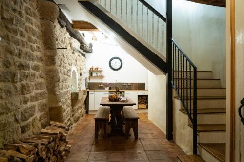 a kitchen with a table and stairs in a building at Número 8 a Traditional Basque Village Homestead in Laguardia