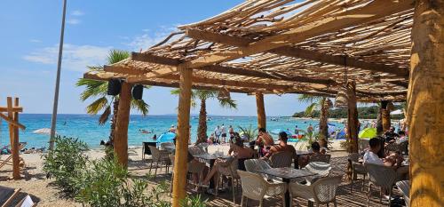 a group of people sitting at tables on the beach at Apartment Tonci in Novalja