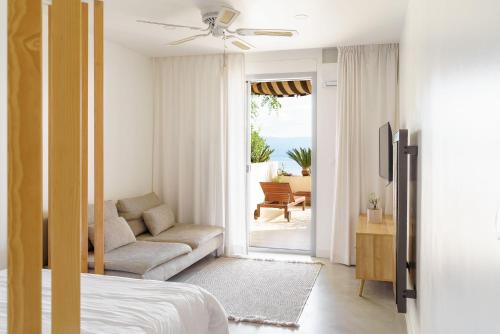een slaapkamer met een bed, een bank en een patio bij Destinu Marinella in Ajaccio