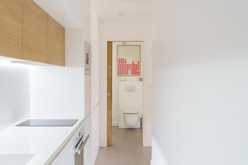 een witte badkamer met een toilet en een hal bij Destinu Marinella in Ajaccio