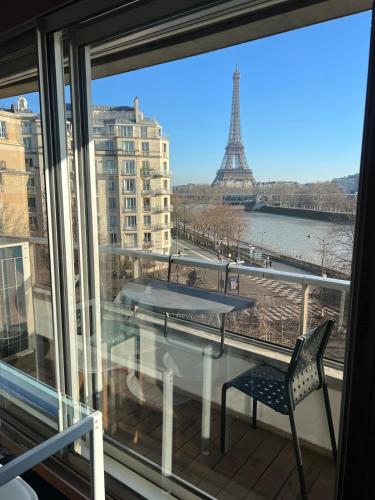d'un balcon avec une table et une vue sur la tour Eiffel. dans l'établissement Luxury Suite View Eiffel Tower Paris 16th Trocadero, à Paris