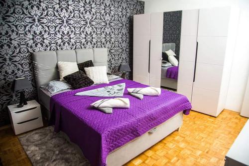 a bedroom with a purple bed with a purple blanket at Bulevar Apartman BL in Banja Luka