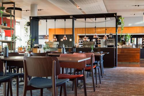a restaurant with tables and chairs and a bar at Clarion Hotel Bergen Airport in Bergen