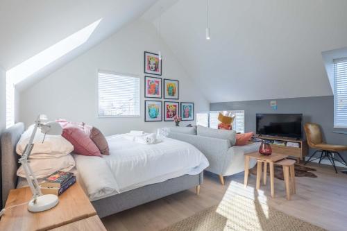 a bedroom with a bed and a couch and a television at Beautiful Central Apt With Parking in Cambridge