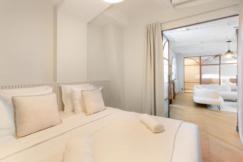 - une chambre blanche avec un lit et un salon dans l'établissement Luxury Apartment Saint Honore I, à Paris