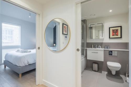 a bathroom with a bed and a sink and a mirror at Superb Central Apt With Parking in Cambridge