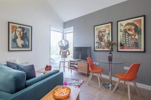 a living room with a blue couch and orange chairs at Superb Central Apt With Parking in Cambridge