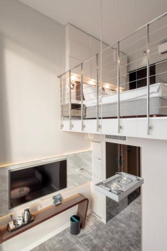a kitchen with white cabinets and a bed in it at Marine Hotel by Zdrojowa in Kołobrzeg