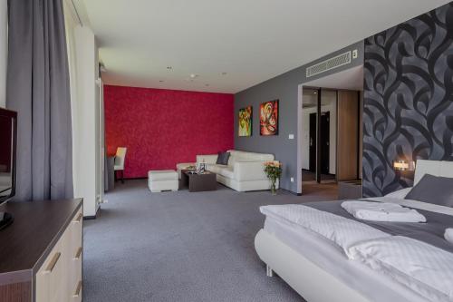 a bedroom with a bed and a living room at Hotel TENIS in Zvolen