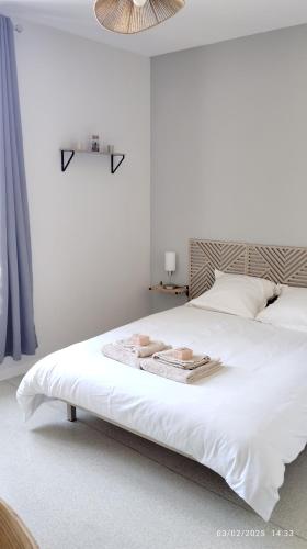 une chambre avec un grand lit avec des draps blancs dans l'établissement Studios ou Chambre SDB avec extérieur centre-ville Ribérac, à Ribérac