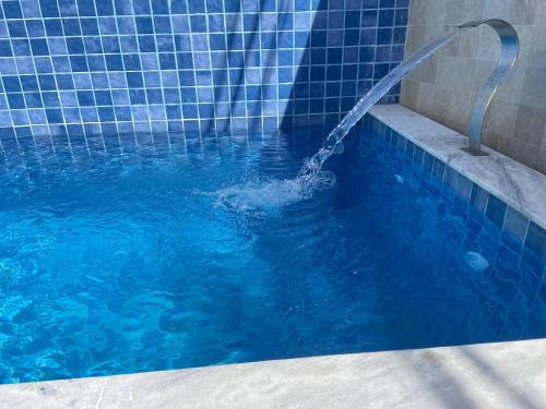 a person in a swimming pool with a water hose at Casa de praia Jacuipe Condomínio Planeta Água 1 in Campos