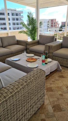 un patio con divani e un tavolo con una pizza sopra di Villa Sunshine a Bar