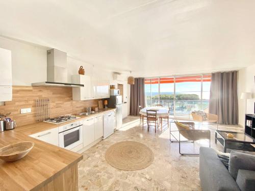 une cuisine et un salon avec un canapé et une table dans l'établissement APPARTEMENT CLIMATISE 2 CHAMBRES VUE MER ET PARKING, au Grau-du-Roi