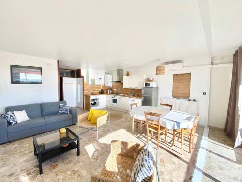 un salon avec un canapé et une table dans l'établissement APPARTEMENT CLIMATISE 2 CHAMBRES VUE MER ET PARKING, au Grau-du-Roi