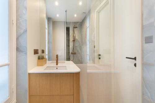 une salle de bain avec un lavabo et une douche dans l'établissement Luxury Apartment Saint Honore II, à Paris