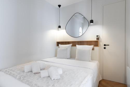 - une chambre blanche avec un lit blanc et un miroir dans l'établissement Luxury Apartment Saint Honore II, à Paris