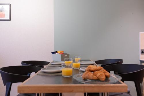 a table with a plate of croissants and glasses of orange juice at Newly Refurbed Warwick Apt 2BR Sleeps 3 Free Parking in Warwick