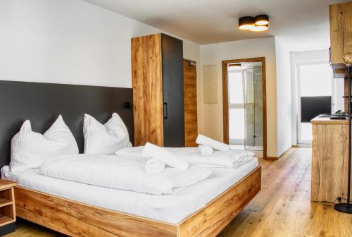 a bedroom with a large bed with white pillows at myQuartier City Chalets in Innsbruck