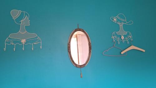 un miroir et une figurine d'une femme dans l'établissement Chambre - Maison La Libéllule, à Besançon