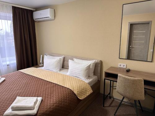 a hotel room with a bed with a desk and a mirror at Yavir in Poltava
