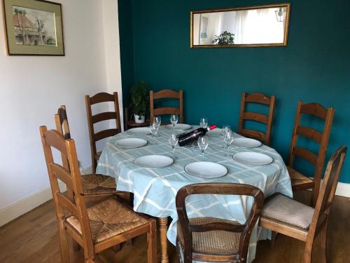 tavolo da pranzo con sedie e parete blu di Chambre avec sdb privative - Maison La Libéllule a Besançon